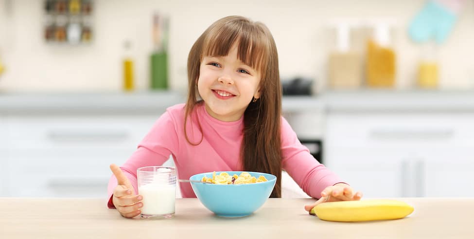 smiling girl eating breakfast